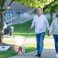 Couple walking dog on the sidewalk of Kirkhof Lawn.